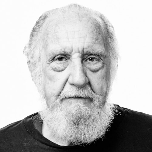 Black and white headshot of an elderly man with a long beard and intense expression.