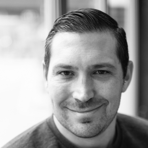 A grayscale portrait of Peter Ragonetti, a man with neatly styled hair and a friendly expression, wearing a crew-neck shirt, looking directly at the camera.