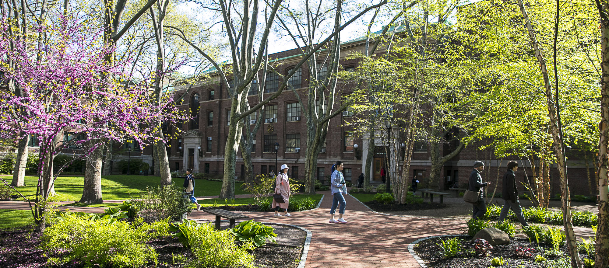 Students walking across Pratt's Brooklyn campus on a crisp spring day.